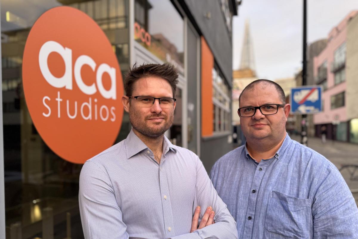 Two men with glasses in front of an 'ACA Studios' logo