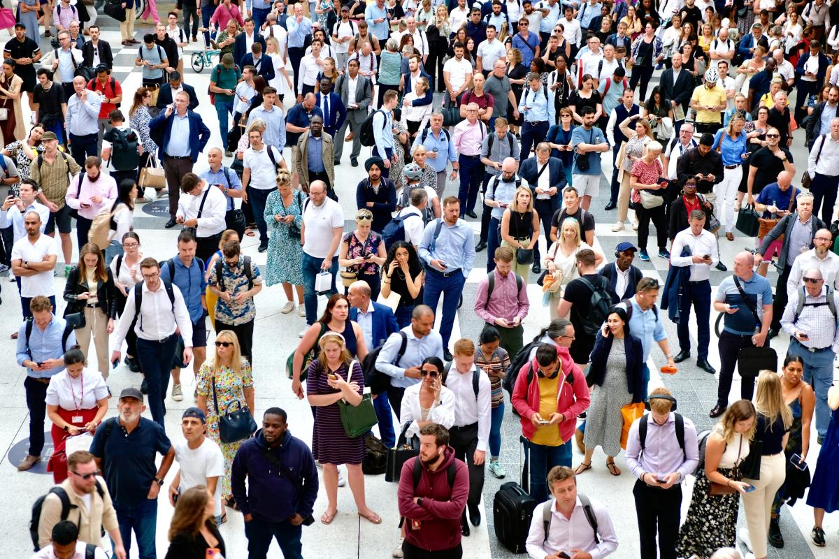 A crowd of people waiting for a train at Liverpool Street, London.