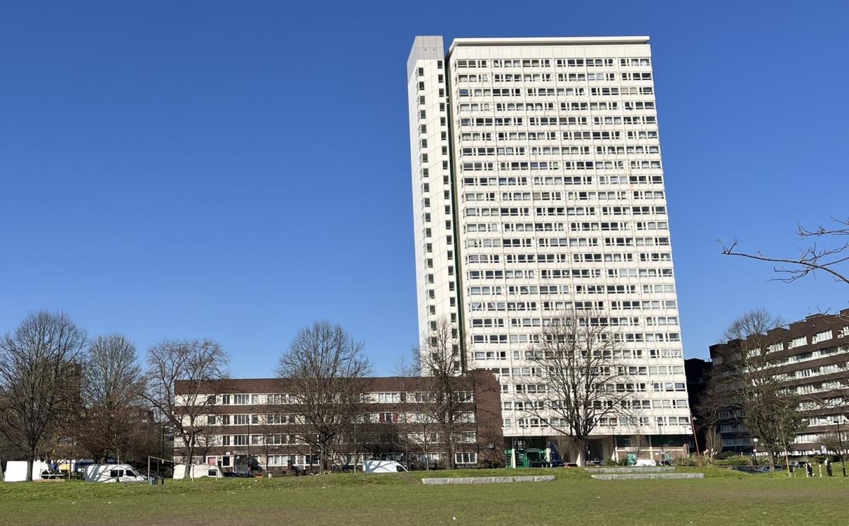 Tall white apartment building with a small block of flats to the left