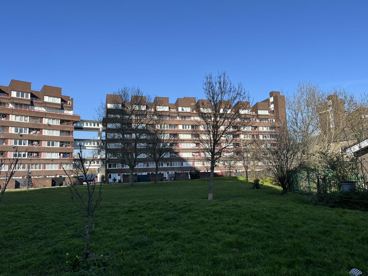 Brick road council flats with a large grassy area in front