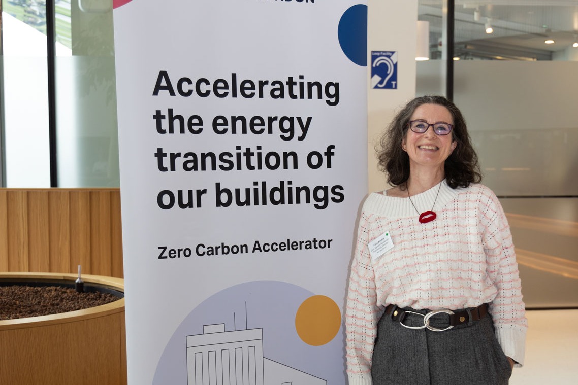 Women with glasses standing next to a banner that says 'Accelerating the energy transition of our buildings'
