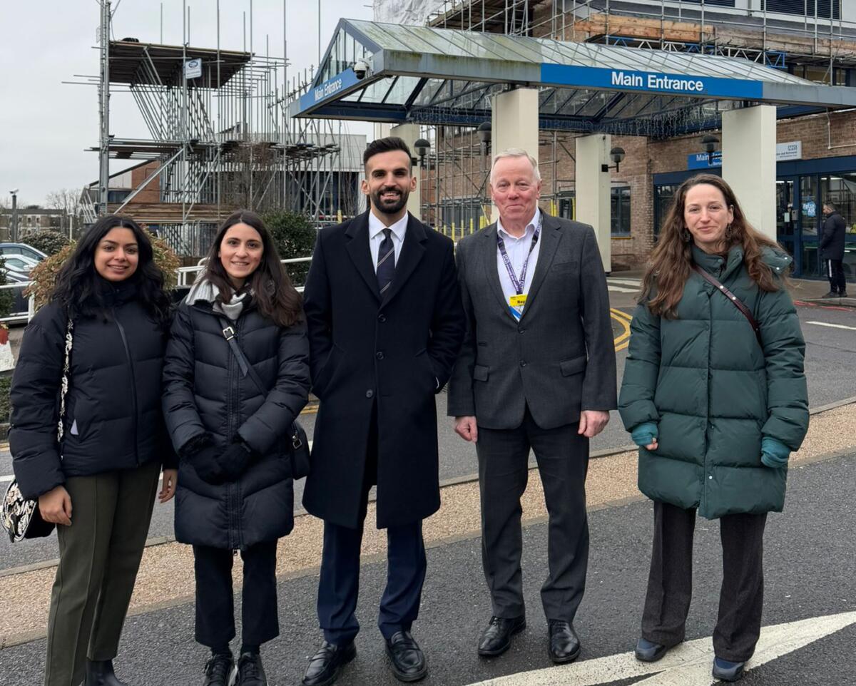 Five people standing in front of a hospital entrance